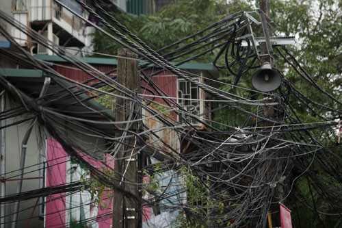 Hình ảnh chiếc loa phường giữa dây điện, dây cáp chằng chịt có lẽ chỉ có ở Hà Nội. Ảnh: Dân Việt.