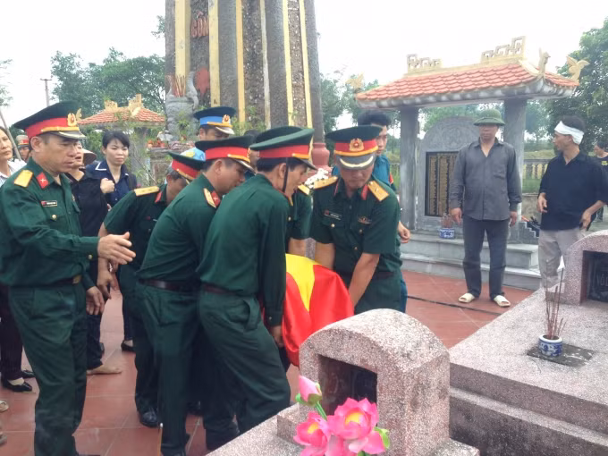 Nâng phần tro cốt của đồng đội đã hi sinh đưa về nơi an nghỉ cuối cùng.