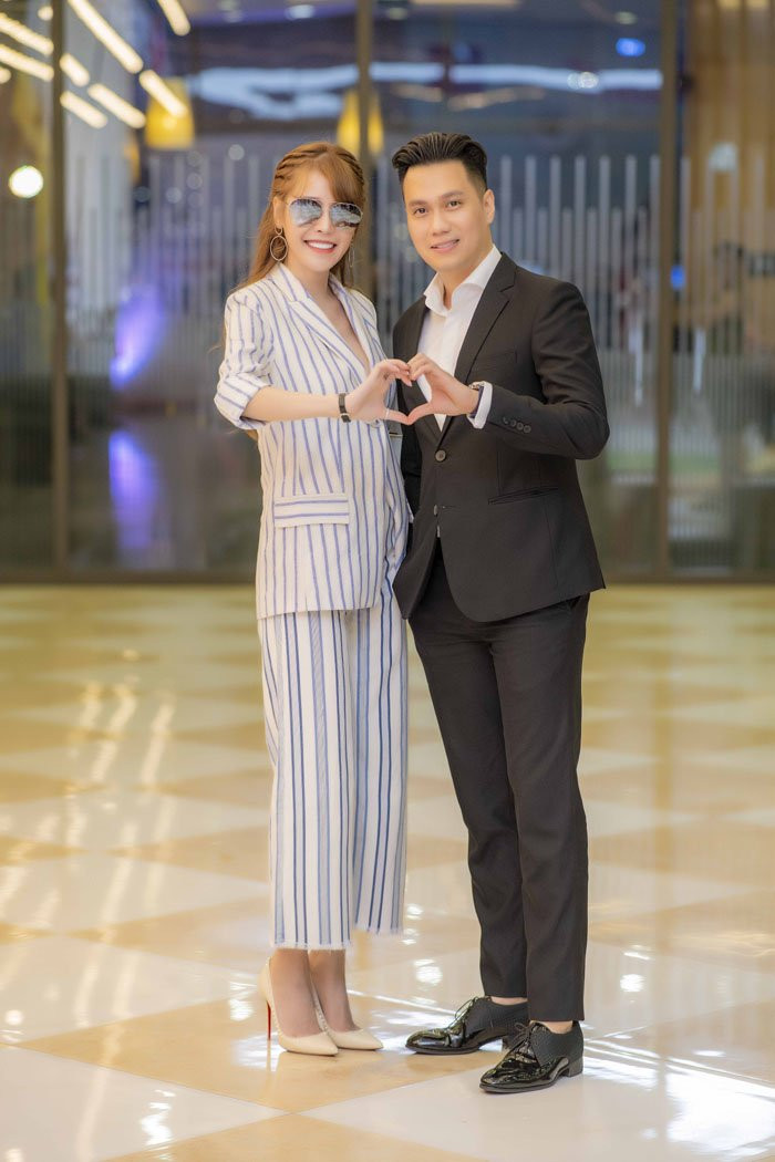 Không chỉ lựa chọn trang phục với tone đen - trắng khi tham gia sự kiện, cặp đôi thoải mái tạo biểu tượng trái tim tạo dáng trước ống kính.