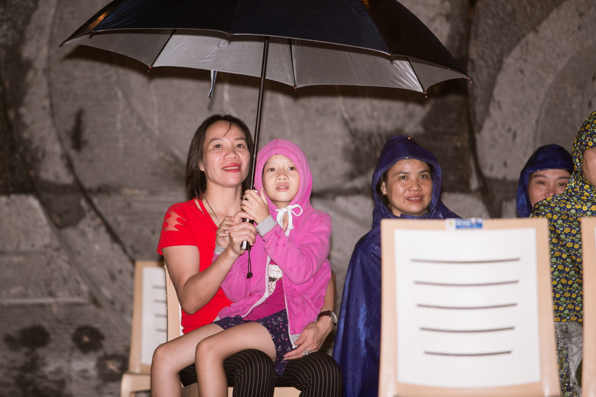 Tuy trời mưa và khá khuya nhưng người dân Cửa Lò vẫn nán lại quảng trường, đội mưa xem tổng duyệt.