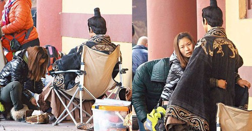 Hình ảnh Trịnh Gia Dĩnh để nữ trợ lý chỉnh sửa trang phục, đi tất và thắt lưng cho trong khi anh ngồi trên ghế phì phèo thuốc lá khiến nam diễn viên bị chỉ trích gay gắt.