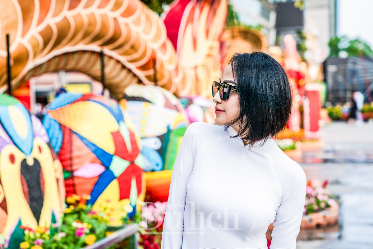 Chị Hoàng Thị Bích Duyên nền nã trong tà áo dài trắng, tạo dáng trước các chú rồng linh vật của năm 2024, hân hoan chia sẻ, diện mạo cổng chào Đường hoa Xuân năm nay rực rỡ đầy sắc màu; đặc biệt là 2 chú rồng tại đây có thể chuyển động phần đầu, trông rất sinh động.