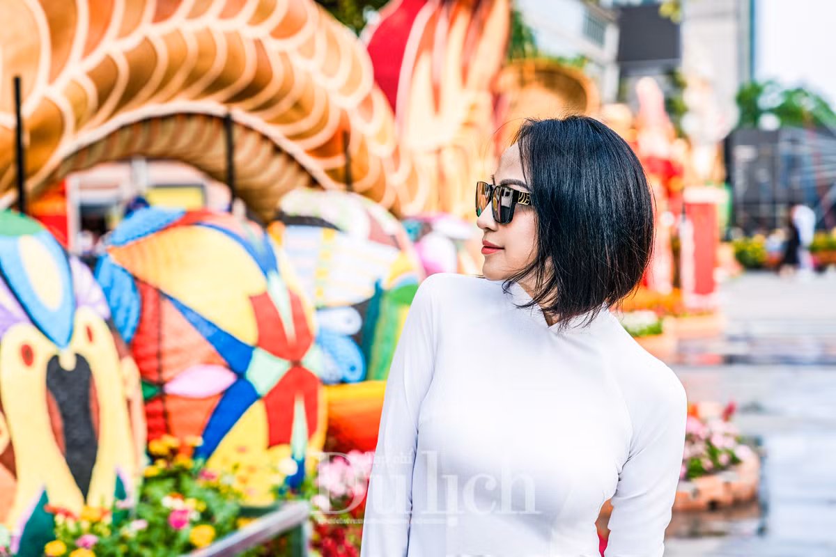 Chị Hoàng Thị Bích Duyên nền nã trong tà áo dài trắng, tạo dáng trước các chú rồng linh vật của năm 2024, hân hoan chia sẻ, diện mạo cổng chào Đường hoa Xuân năm nay rực rỡ đầy sắc màu; đặc biệt là 2 chú rồng tại đây có thể chuyển động phần đầu, trông rất sinh động.