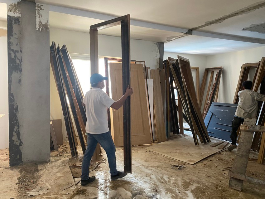 Các công nhân đang vận chuyển các vật liệu gỗ ra bãi tập kết. (Ảnh: Pháp luật TP.HCM).