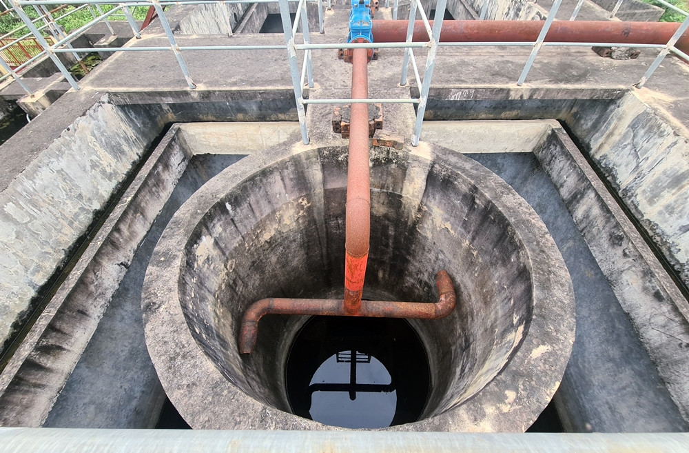 Bên trong bể xử lý nước lắng đọng chút nước mưa đen xì, bốc mùi hôi thối.
