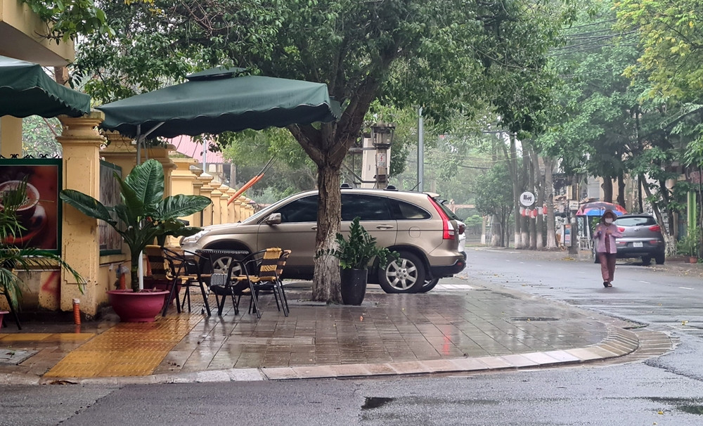 Xe ô tô đỗ vô ý thức, bàn ghế bày tràn lan trên vỉa hè buộc người đi bộ phải “né” xuống lòng đường.