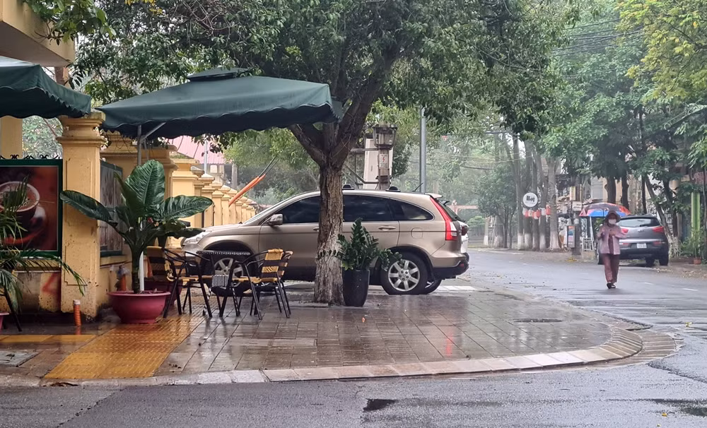 Xe ô tô đỗ vô ý thức, bàn ghế bày tràn lan trên vỉa hè buộc người đi bộ phải “né” xuống lòng đường.