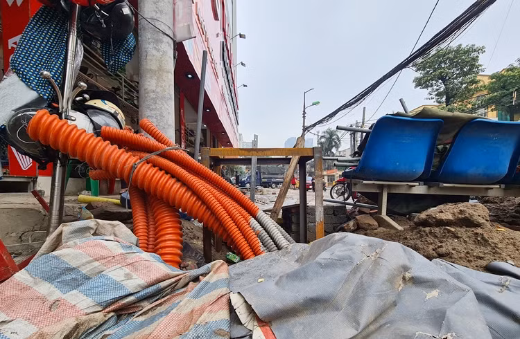 Cảnh tượng vỉa hè đào xới, đường cáp điện,... ngổn ngang trên vỉa hè phố Vũ Trọng Phụng. “Trời nắng đi qua đây đường bụi mù mịt, mưa xuống thì lầy lội, tắc nghẽn giao thông. Không biết khi nào dự án mới hoàn thiện?” - anh Bá Cường (một người dân) chia sẻ.