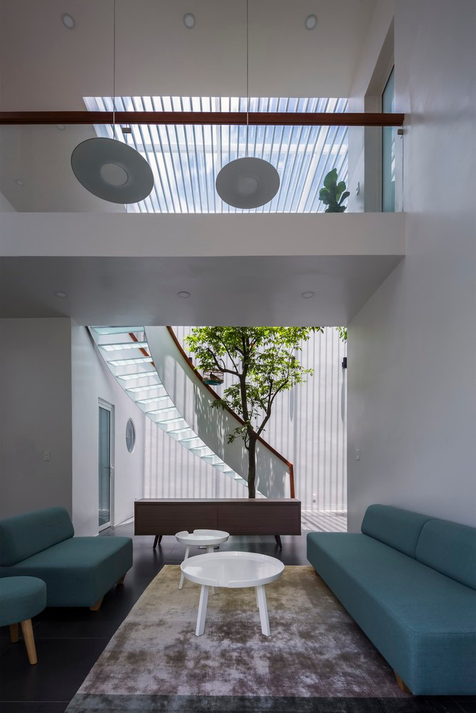 Bộ ghế sofa màu xanh ngọc tạo điểm nhấn ấn tượng trong khu vực tiếp khách.