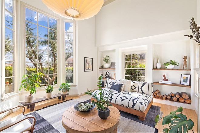 Phòng khách thoáng đãng, sáng sủa với trần nhà cao và những ô cửa kính mang lại ánh sáng tự nhiên. Những nội thất bằng gỗ được thiết kế đơn giản mang lại những nét đẹp mộc mạc và cảm giác ấm áp, gần gũi.