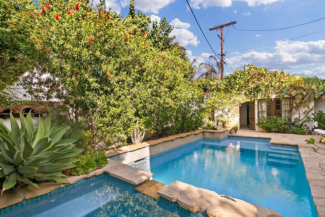 Hồ bơi ngoài trời được thiết kế độc đáo, nằm giữa không gian sân vườn xanh mướt với nhiều loại cây khác nhau.