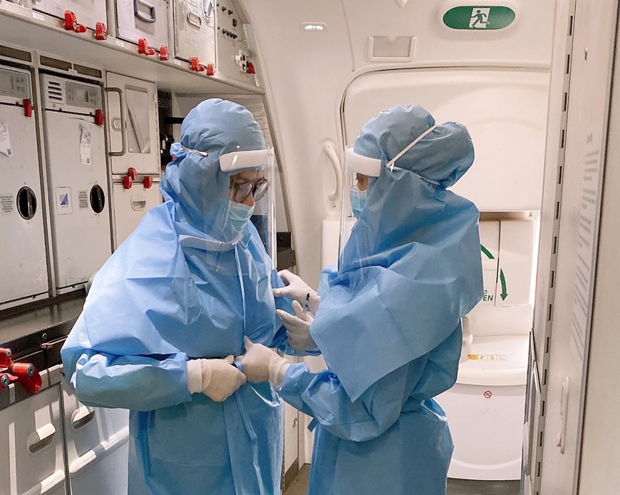 Việc mặc trang phục bảo hộ giúp ngăn chặn nguy cơ lây nhiễm COVID-19. (Ảnh: VNA cung cấp)