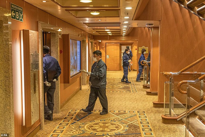 Các nhân viên y tế đeo khẩu trang đi lại ở tầng 6 của con tàu, kiểm tra thân nhiệt hành khách và thực hiện các xét nghiệm theo yêu cầu. Ảnh: PA.