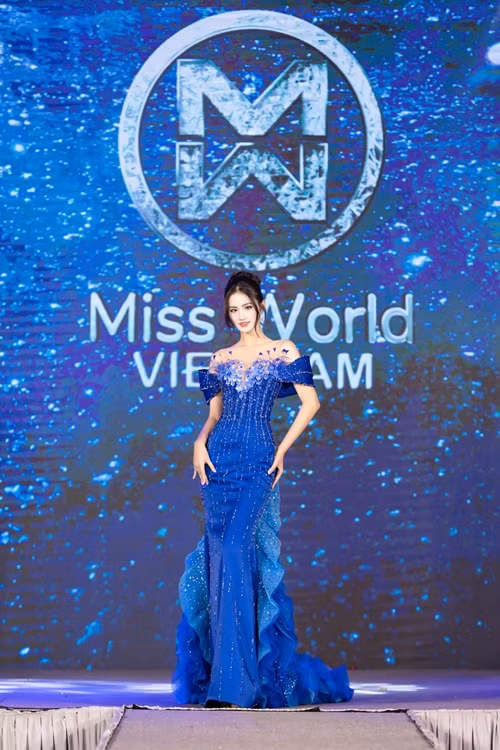 Bộ đầm màu xanh mang tên Aurora of the sea của NTK Hoàng Tony lấy cảm hứng từ hiện tượng cực quang hiếm gặp trên biển – nơi sóng nước giao hòa cùng bầu trời tạo nên những vệt sáng kỳ ảo. Thiết kế trễ vai vừa gợi cảm vừa sang trọng được đính kết tỉ mỉ. Phần tà váy được xử lý xếp tầng mềm mại, gợn sóng uyển chuyển. Ảnh: FB Ý Nhi.