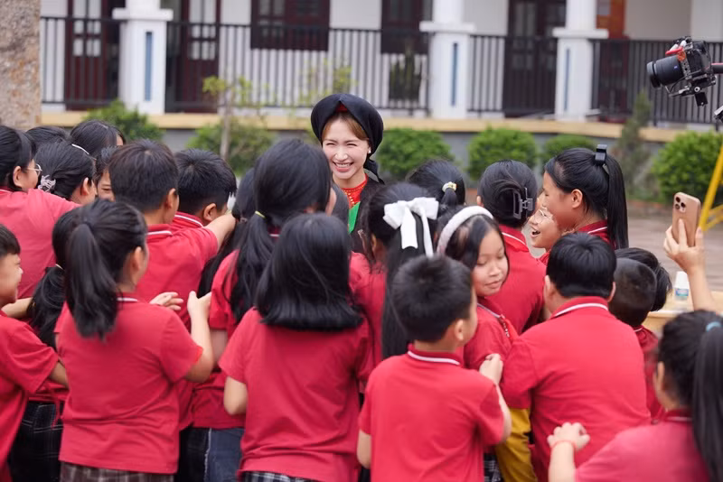 Hòa Minzy được nhiều em học sinh vây quanh khi xuất hiện.