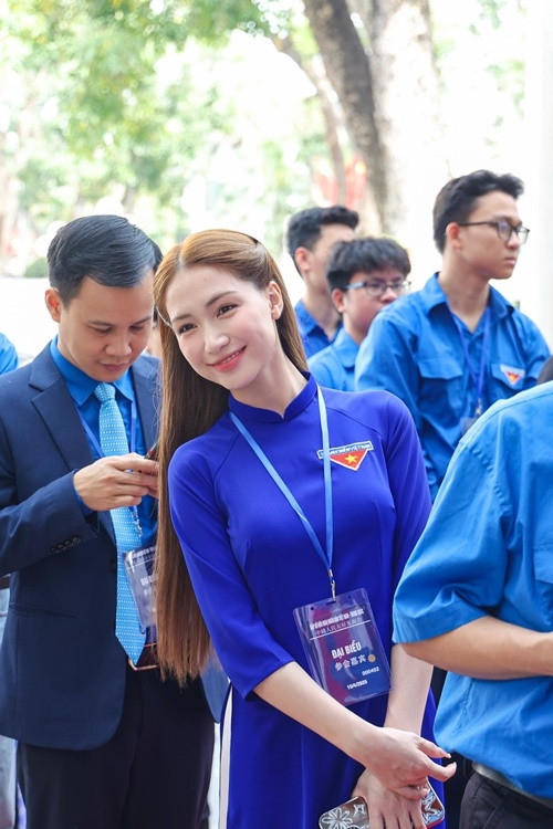 Nữ ca sĩ diện áo dài màu xanh, khoe vẻ rạng rỡ.