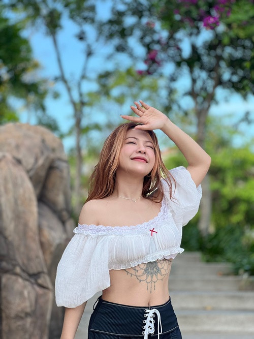 Nữ ca sĩ diện áo hở eo khoe hình xăm "khủng" trong chuyến đi biển.