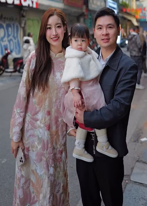 Bé Tuệ An đi giày búp bê, mặc áo dài, áo khoác lông đón Tết cùng bố mẹ.