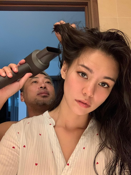 Đạo diễn Quang Dũng hỗ trợ Bùi Lan Hương việc nhà. Anh còn ân cần chăm sóc bạn gái. "Động tác thì hơi vụng về nhưng rất thích sấy tóc cho tôi", Bùi Lan Hương cho biết.