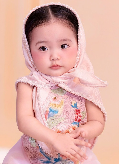 "Lisa lên đồ tiến thẳng về Bắc Ninh được chưa ạ. Chạy vô MV cô Hòa Minzy mượn đồ chú Cao Minh Tiến. Lisa mới 18 tháng rồi ạ", Khánh Thi chia sẻ.