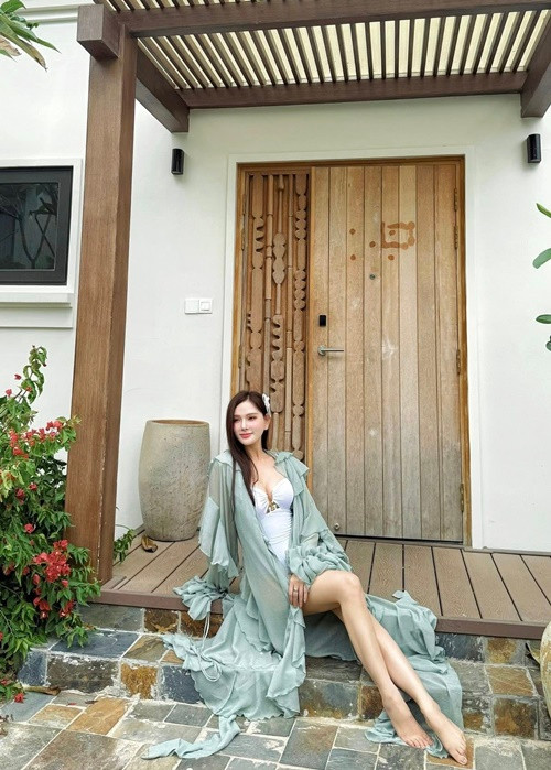 Giọng ca sinh năm 1994 diện áo tắm một mảnh kết hợp cùng áo choàng xuyên thấu.