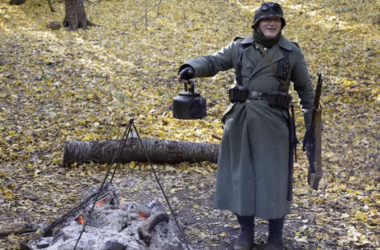 Một diễn viên đóng vai lính đun nước giữa rừng.