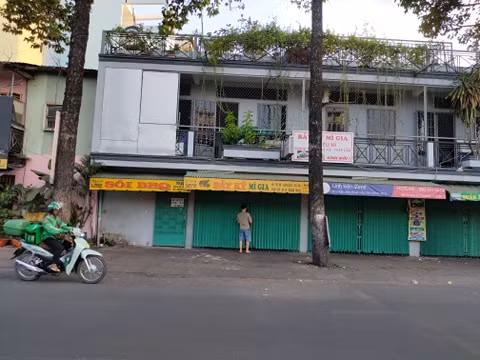 Một người đang đóng cửa quán nhậu, sau khi thu xếp xong bàn ghế.