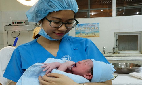 Bác sĩ trẻ Lưu Minh Trâm vui mừng đón một em bé vừa mới chào đời trong ca trực giao thừa đầu tiên - Ảnh: VŨ THỦY