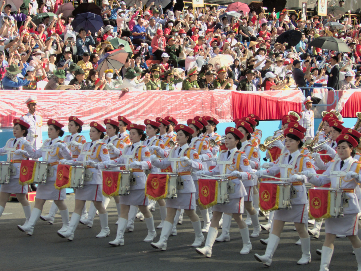 Khối nữ quân nhạc mặc quân phục màu trắng, đội mũ beret đỏ, đeo găng tay trắng và thắt lưng vàng.