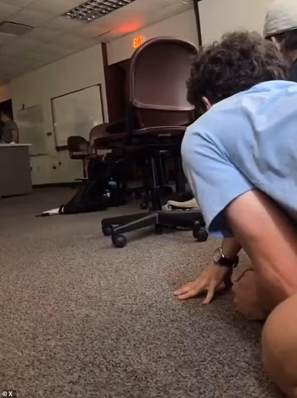 Một sinh viên chia sẻ đoạn video được quay bên trong lớp học cho thấy nhiều người sợ hãi co ro dưới gầm bàn. Ảnh: X.