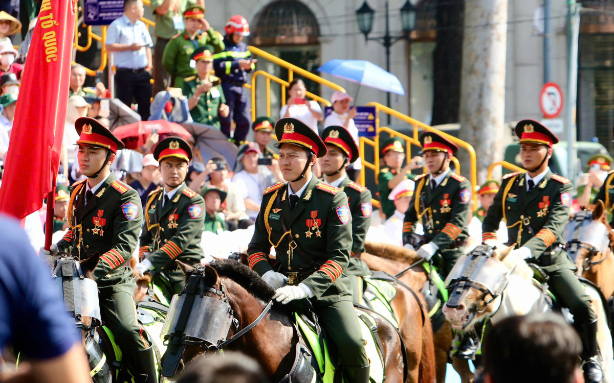 Khối cảnh sát cơ động kỵ binh mặc lễ phục màu xanh ô liu đậm viền đỏ, đội mũ kê-pi, đeo huân chương.