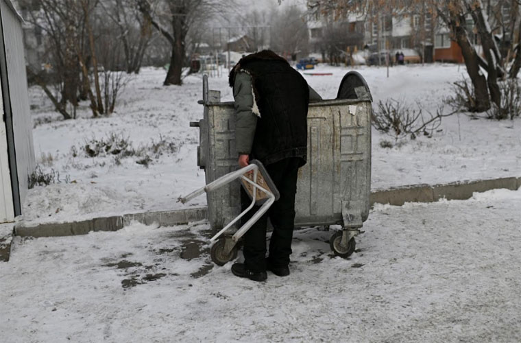 Một người đàn ông đang bới rác.