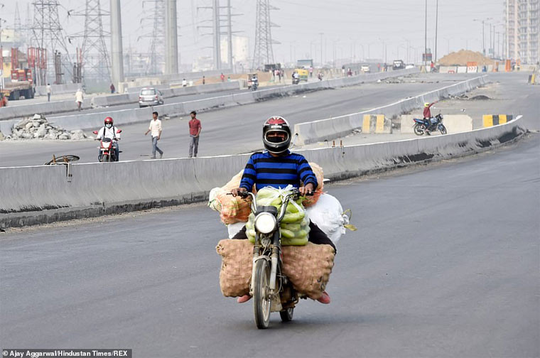 Một người đàn ông đi xe máy chở rau quả. Hiện Ấn Độ ghi nhận khoảng 500 người bị nhiễm Covid-19. Tuy nhiên, mọi người lo lắng khi điều kiện sống của người dân chật chội, nghèo đói, vệ sinh kém, hệ thống y tế yếu sẽ khiến đất nước này nhanh chóng bị Covid-19 hạ gục.