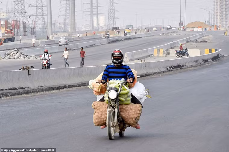 Một người đàn ông đi xe máy chở rau quả. Hiện Ấn Độ ghi nhận khoảng 500 người bị nhiễm Covid-19. Tuy nhiên, mọi người lo lắng khi điều kiện sống của người dân chật chội, nghèo đói, vệ sinh kém, hệ thống y tế yếu sẽ khiến đất nước này nhanh chóng bị Covid-19 hạ gục.