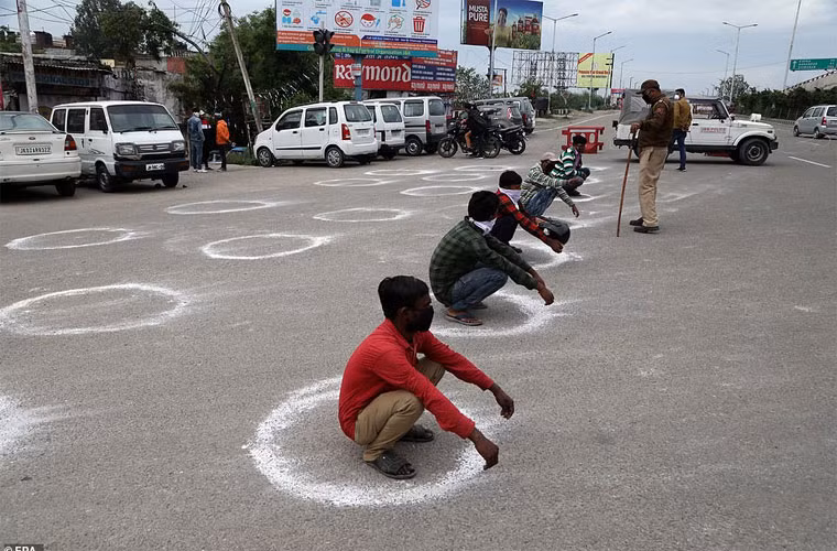 Những người đàn ông bị bắt quả tang vi phạm lệnh giới nghiêm khi tụ tập đông người đã bị buộc phải ngồi trong những vòng tròn vẽ bằng phấn trên nền đất để họ biết khoảng cách tối thiểu giữa người với người khi Ấn Độ đang thực hiện lệnh cấm túc vì Covid-19.