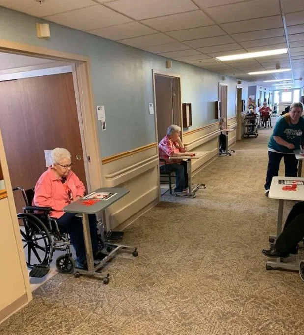 Các cụ già tìm cách xả "stress" bằng việc chơi game Bingo ở ngoài hành lang mà vẫn chấp hành giữ khoảng cách như yêu cầu trong bối cảnh dịch Covid-19 bùng phát mạnh trên thế giới. (Nguồn ảnh: The Sun)