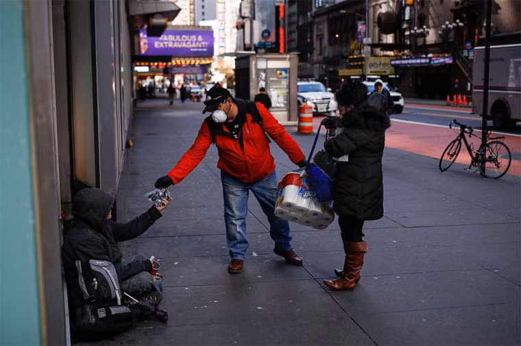 Bà Virna Munoz-Guzman cùng chồng đi phát nước rửa tay khô và găng tay dùng một lần cho những người vô gia cư trên phố 42 ở New York.