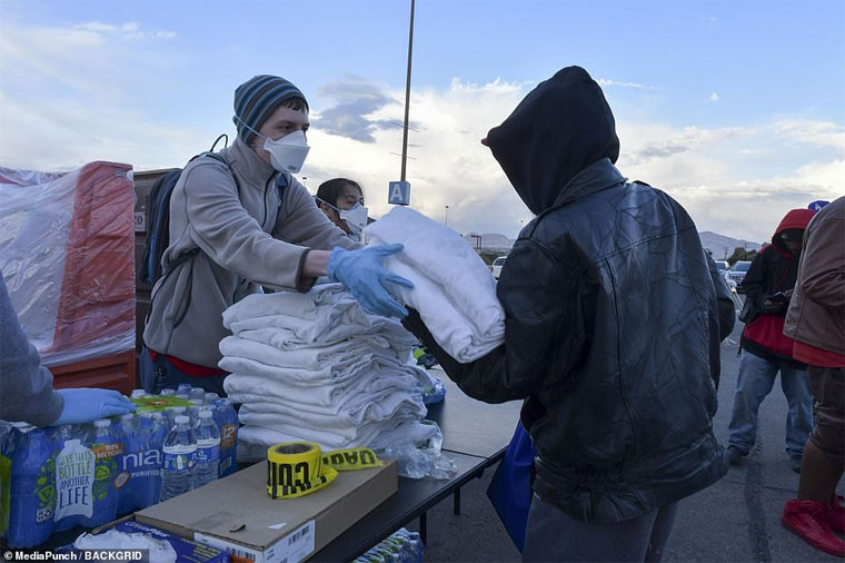 Những tình nguyện viên mang nước và chăn tới cho những người vô gia cư ở khu tạm trú.