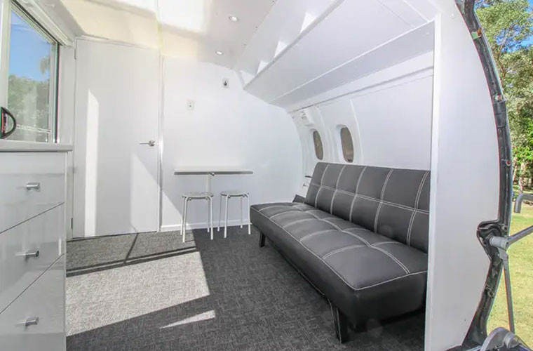 Bên trong ngôi nhà có bếp, phòng khách, phòng tắm. Chiếc bàn bên cạnh ghế sofa có thể gập gọn vào để thêm diện tích cho phòng khách.