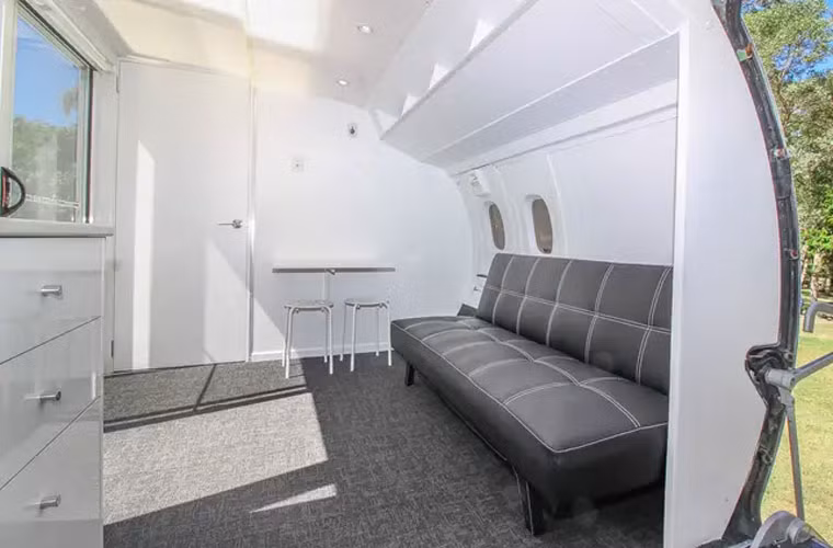 Bên trong ngôi nhà có bếp, phòng khách, phòng tắm. Chiếc bàn bên cạnh ghế sofa có thể gập gọn vào để thêm diện tích cho phòng khách.