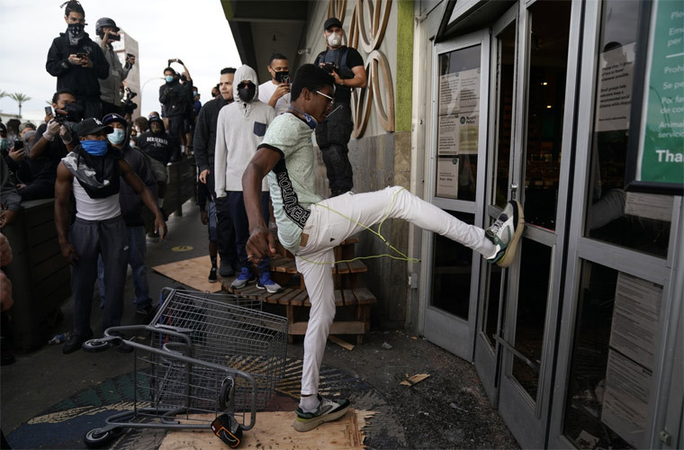 Một người biểu tình đập cửa một siêu thị.