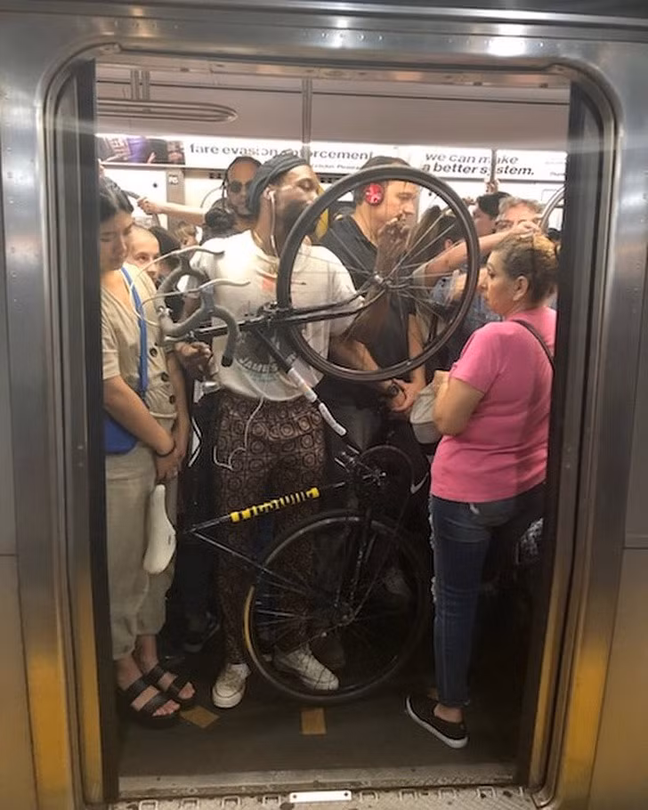 Người đã không còn chỗ đứng, anh chàng này còn vác lên tàu điện ngầm cả chiếc xe đạp.