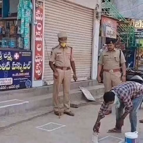 Cảnh sát Ấn Độ đang giám sát một chủ cửa hàng kẻ chỗ đứng cho khách.