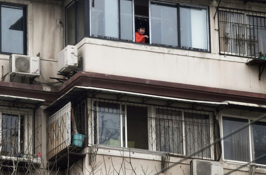 Người đàn ông hút thuốc bên cửa sổ một ngôi nhà ở Vũ Hán.