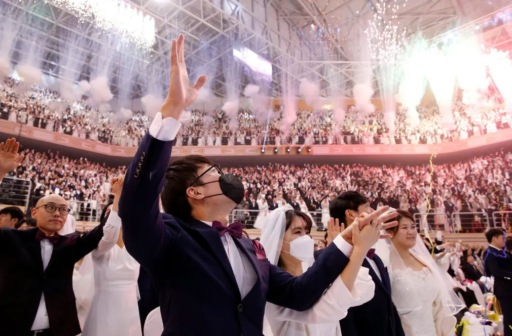 Không khí trong hội trường nơi tổ chức đám cưới tập thể rất rộn ràng, các cặp cô dâu chú rể chụp ảnh chung và được bạn bè và người thân chúc mừng.