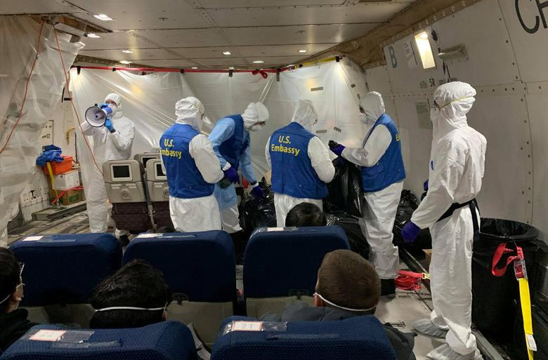 Các nhân viên của Đại sứ quán Mỹ mặc đồ bảo hộ hỗ trợ hành khách trên chuyến bay từ Vũ Hán về Mỹ.