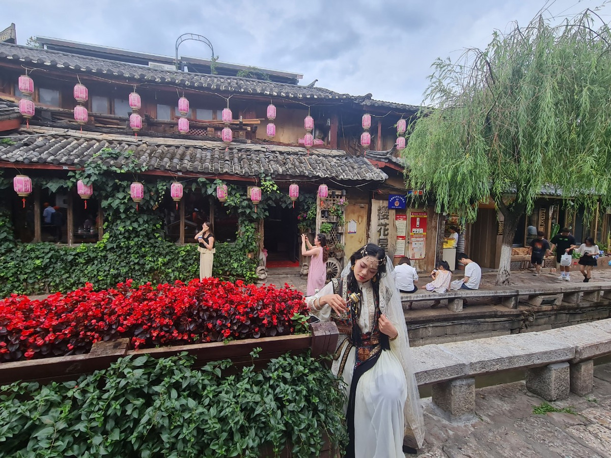 Những thiếu nữ hóa trang trong trang phục cổ khiến cảnh sắc bỗng như quay trở lại cả ngàn năm trước. Những cô gái Nạp Tây mộc mạc, dân dã bỗng hiển hiện ngay trước mắt, ở nơi cổ trấn đẹp tựa chốn thần tiên chỉ nhìn thấy trong phim ảnh.