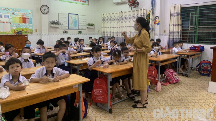 Các bé lớp 1 chưa thích nghi với môi trường mới, nhiều em ngủ trễ đi học muộn, nhà trường hướng dẫn các em đo thân nhiệt, xịt khuẩn tay và vào vị trí lớp học.