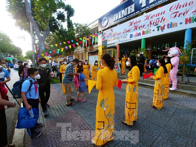 Trường tiểu học Đinh Tiên Hoàng (quận 1) giáo viên mặc áo dài đón học sinh từ cổng. Các em học sinh bắt đầu làm quen với không khí trên lớp 