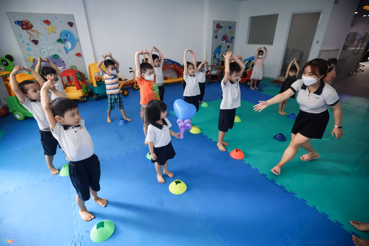 Trong buổi học đầu tiên, giáo viên hướng dẫn các bé cách đeo khẩu trang đúng cách và rửa tay sát khuẩn. "Các con có biết tại sao chúng mình phải nghỉ học không? Do virus ạ, do COVID-19 ạ, cô ơi do dịch bệnh ạ,...", các bé vui vẻ với bài học.